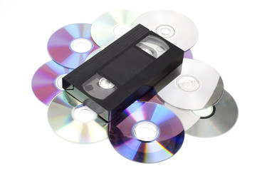 Fototapeta premium CD vs VHS. VHS cassette lay on the many CD disks isolated on whi