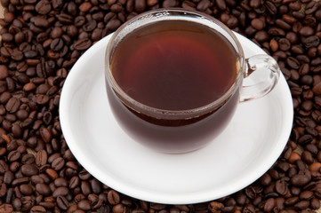 A cup of coffee on the background of coffee beans