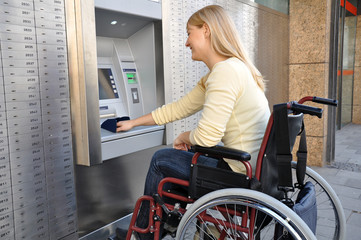 Rollstuhlfahrerin am Geldautomaten