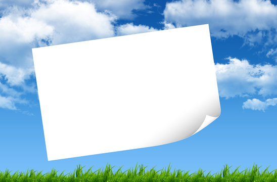 Blank paper, green grass and blue sky