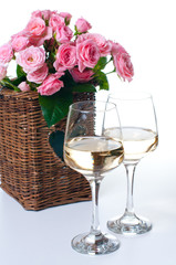 Two glasses of white wine and roses