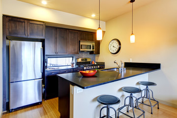 Modern brown kitchen with bar and stools.