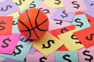 Basketball on pile of  $ symbols.