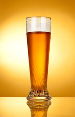 Glass of beer on a yellow background