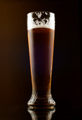 Glass of dark beer on a black background