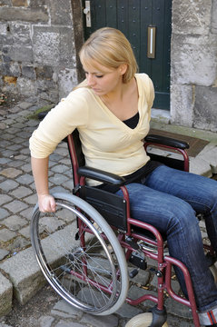 Rollstuhlfahrerin an Bordsteinkante