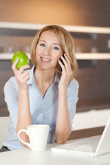 Frau mit Laptop in der Küche