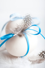 White Easter Eggs with Blue Ribbons and Quail's Feathers