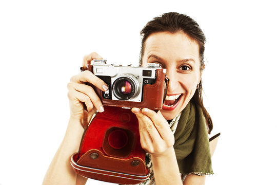 Excited young woman taking a picture with an old camera