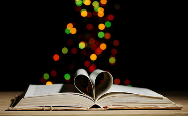 open book on wooden table on bright background