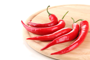 Red hot chili peppers on wooden plank isolated on white