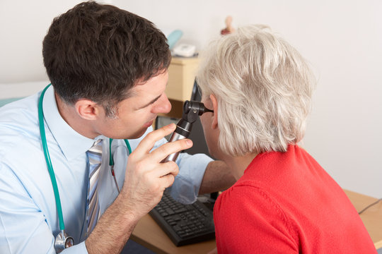 British Doctor Examining Senior Woman's Ear