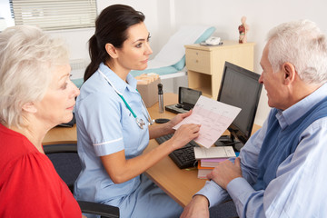Obraz premium British nurse talking to senior couple