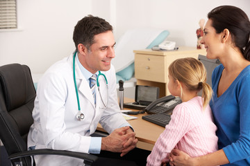 Fototapeta premium American doctor talking to young child and mother