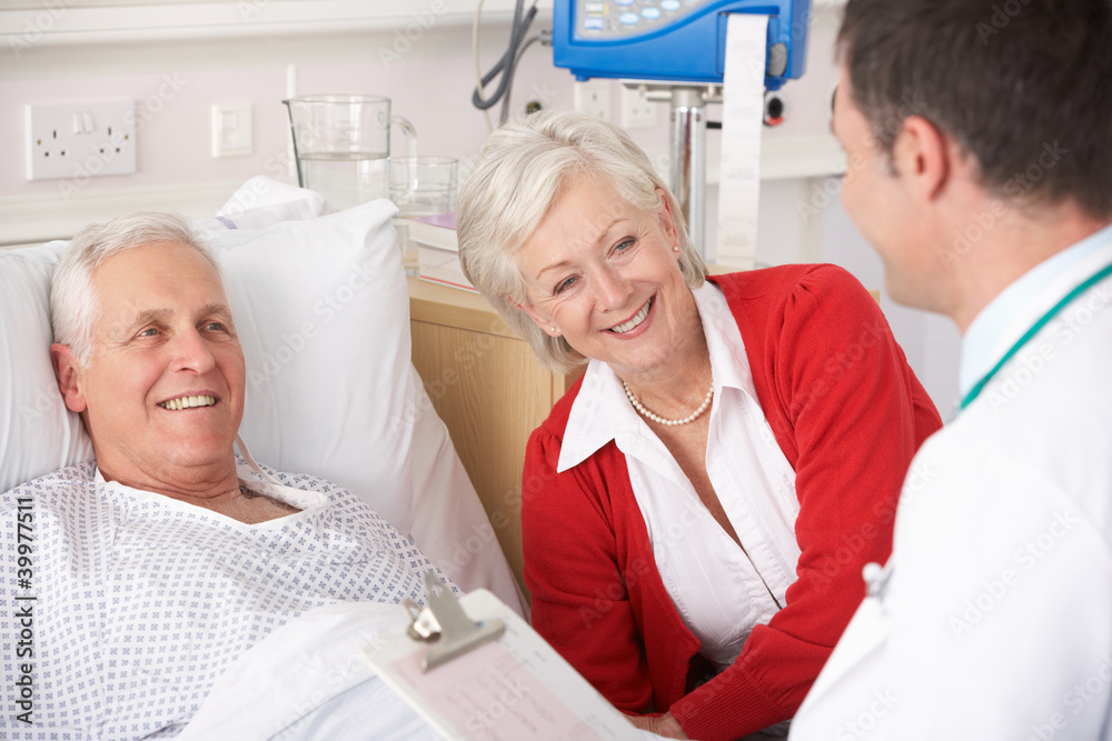 Wall mural Doctor talking to senior couple on USA Hospital ward