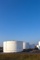 white tank in tank farm with blue sky