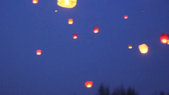 glowing lanternes with burning flame inside flies