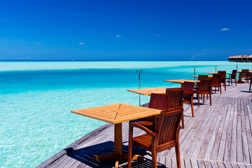 Tables and chairs at tropical beach restaurant