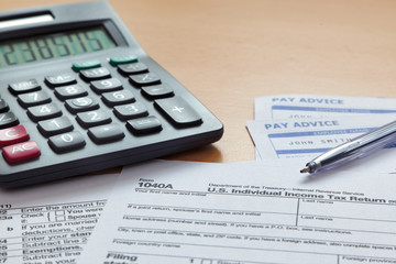 Fototapeta premium 1040 tax return with payslips and calculator