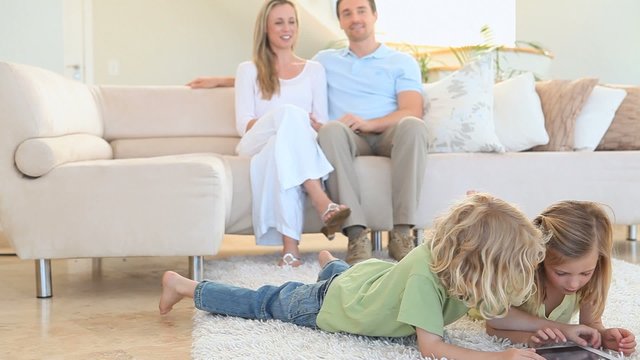 Couple looking their children playing on the floor