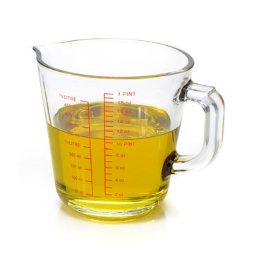 Oil in measuring cup isolated on white background Stock Photo