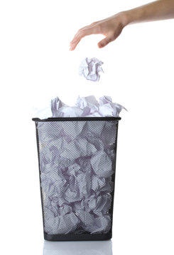 hand going garbage in metal trash bin from paper isolated
