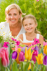 Mother with daughter working in flowers garden