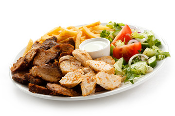 Grilled meat with French fries and vegetables