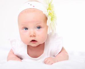 Portrait of a baby girl with a flower on her head