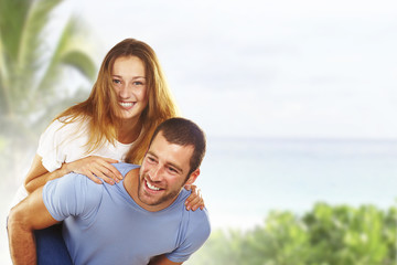 Portrait of a happy young couple having fun together in beach