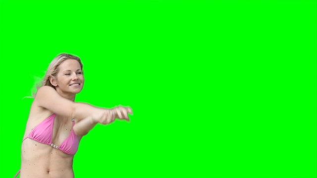 A woman in her bikini passes a beachball back and forth