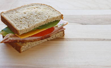 Half Ham and Cheese Sandwich on Wood Cutting Board