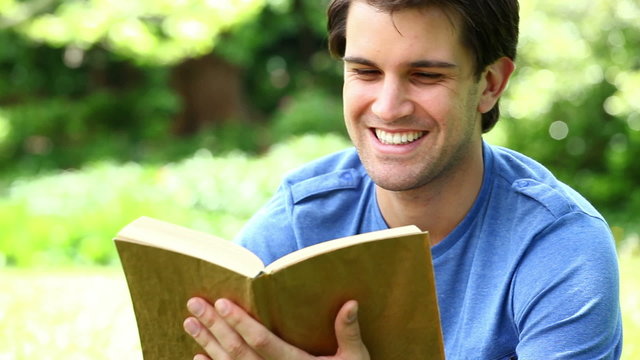 Smiling man reading a fascinating book
