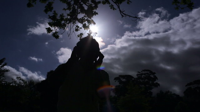 Young man listening to music the in moonlight