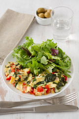 omelet with vegetables and salad on the plate