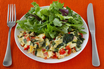omelet with vegetables and salad on the plate