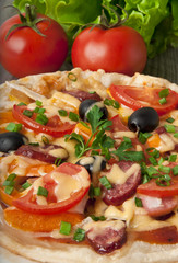 pizza with tomatoes, cheese, black olives and peppers.