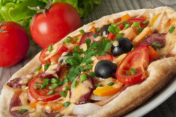 pizza with tomatoes, cheese, black olives and peppers.