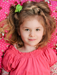 Girl Reclines on Pink Pillow