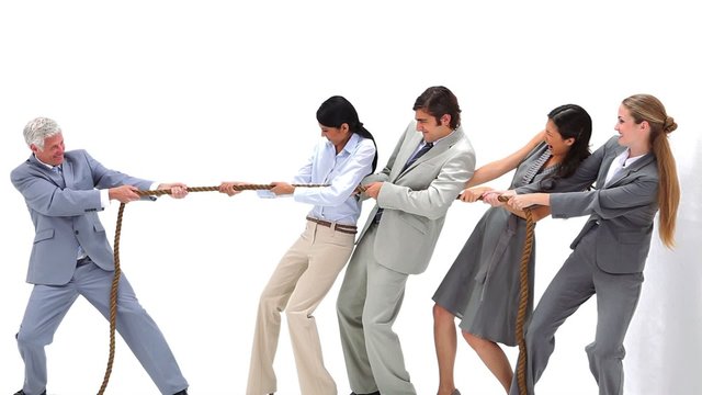 Business team playing Tug-of-War against their boss