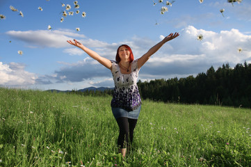 Happy young woman throwing daisy flowers