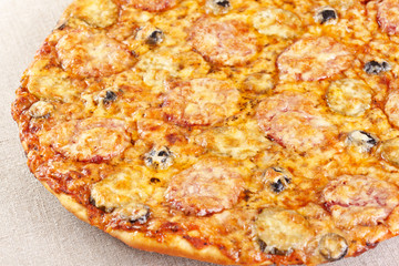 Italian cuisine. Pizza with salami, pickles and olives