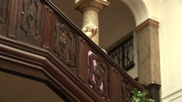 Junge Frau im Abendkleid geht die Treppe runter.