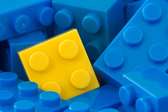 yellow plastic brick in a middle of blue ones