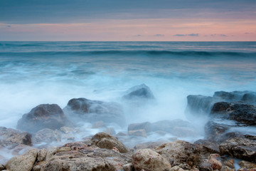 Beautiful rocky sea beach at the sunset