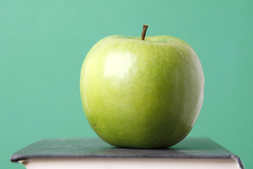 A green apple on a book, closeup