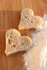 Zwei Brotherzen liegen auf Holztisch