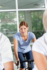 Frau beim Spinning-Kurs im Fitnesscenter