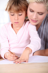 Fototapeta premium Mother teaching daughter to write