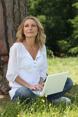 Woman sitting on grass with a computer